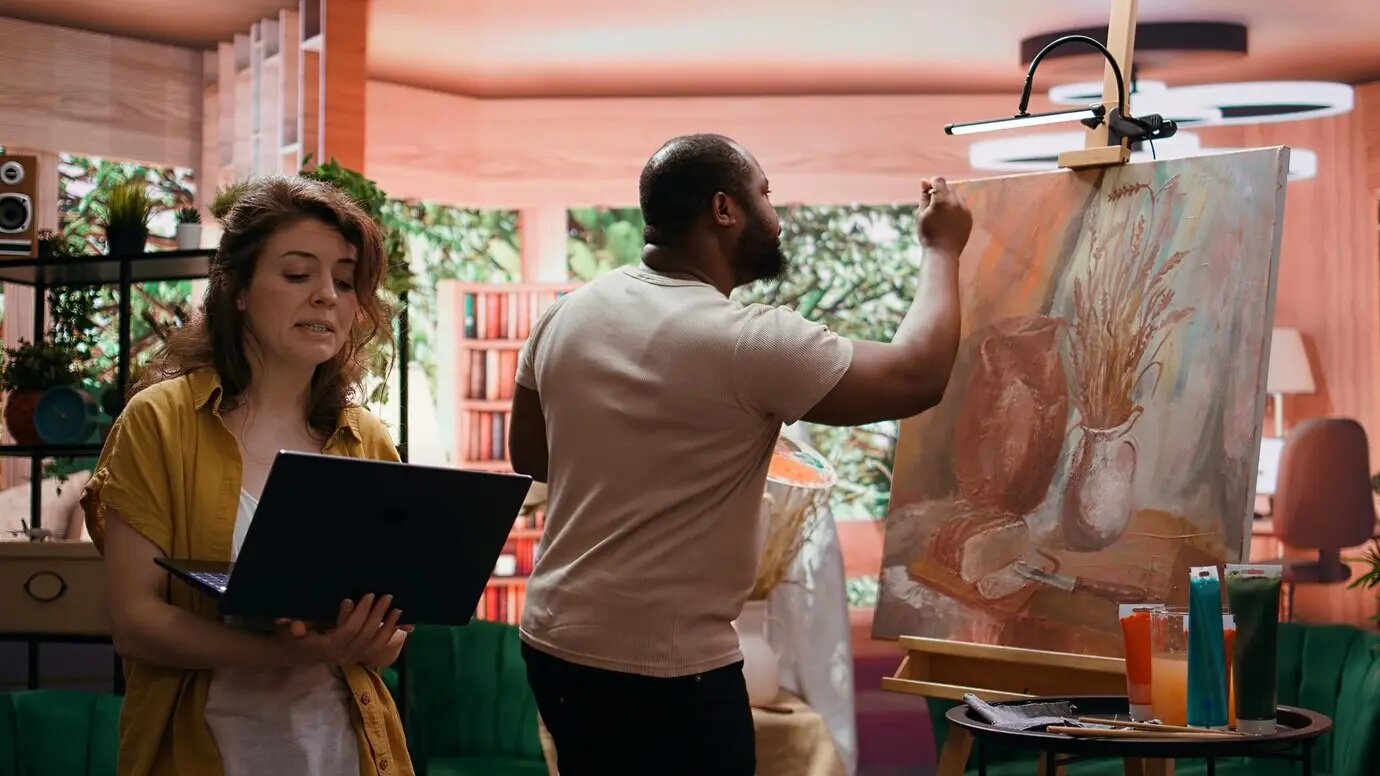 Ein Team von Malern arbeitet in einem Kunst- und Handwerksatelier gemeinsam an einem neuen rustikalen Meisterwerk.