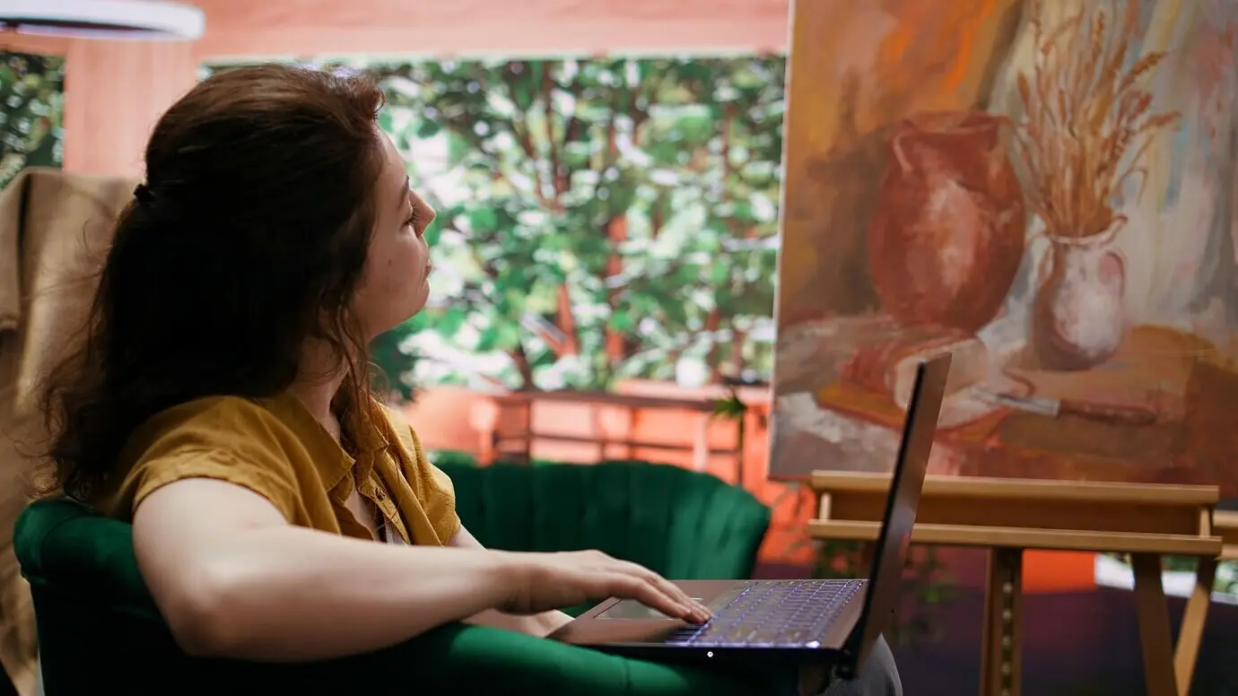 Malerin, die in ihrem Kunst- und Handwerksatelier online nach Inspiration für bildende Kunst sucht